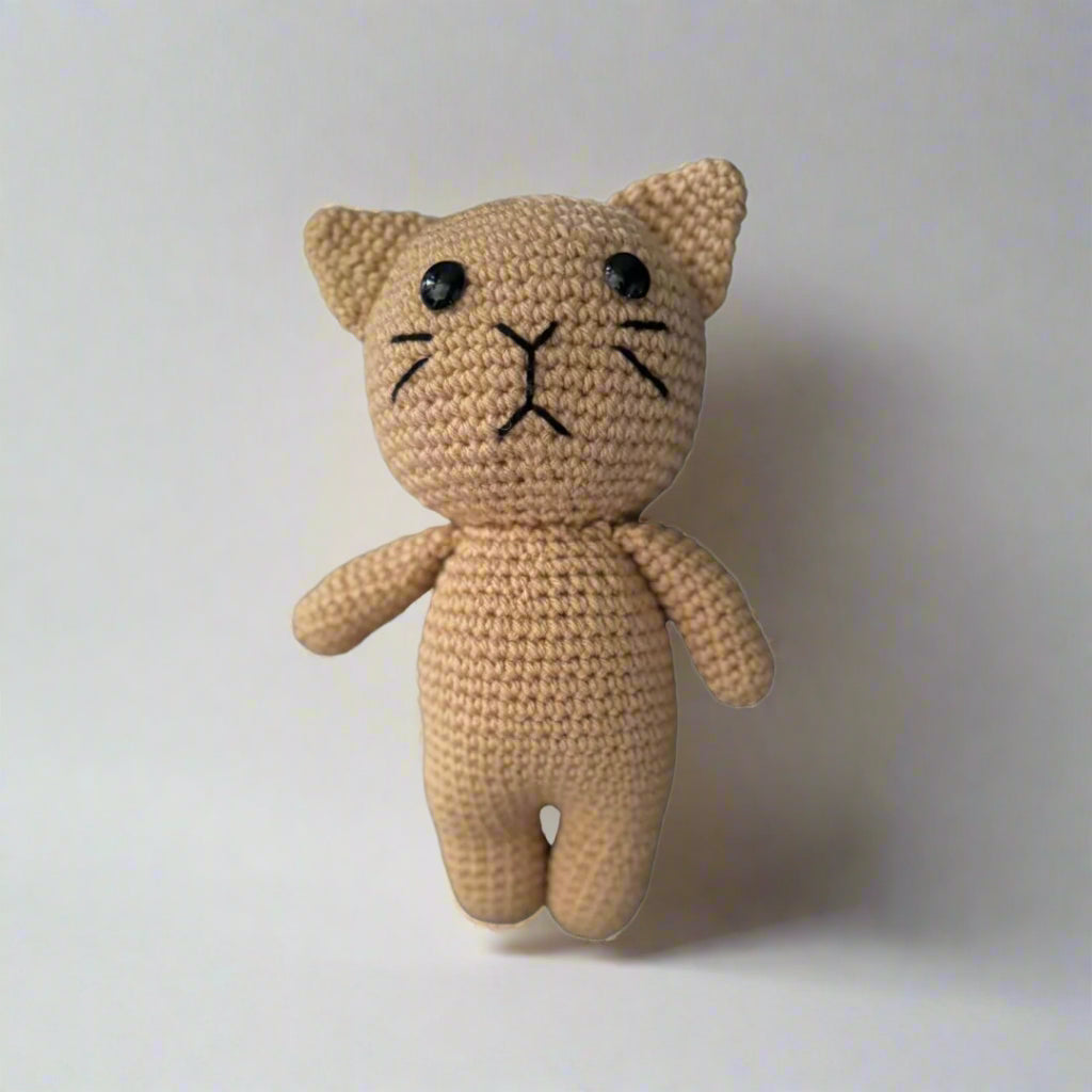 Crochet plush cat placed against a white background
