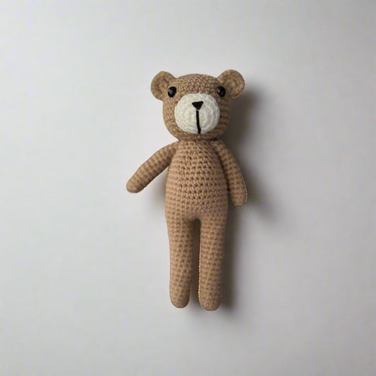 Crochet plush teddy bear placed against a white background