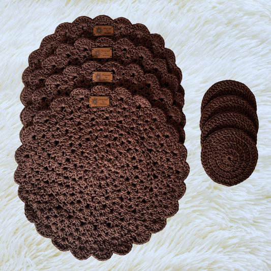 Brown hand crocheted place mats with coasters on top placed on a soft white fabric