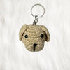 Brown pup face plush keychain placed on a white fur background