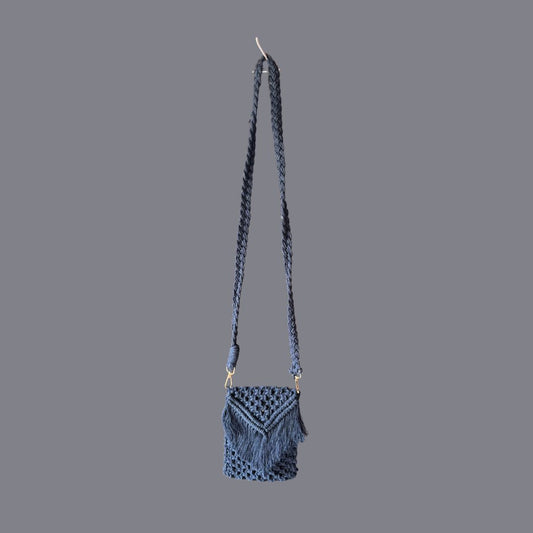 Macrame grey small bag with a long handle placed against a grey background