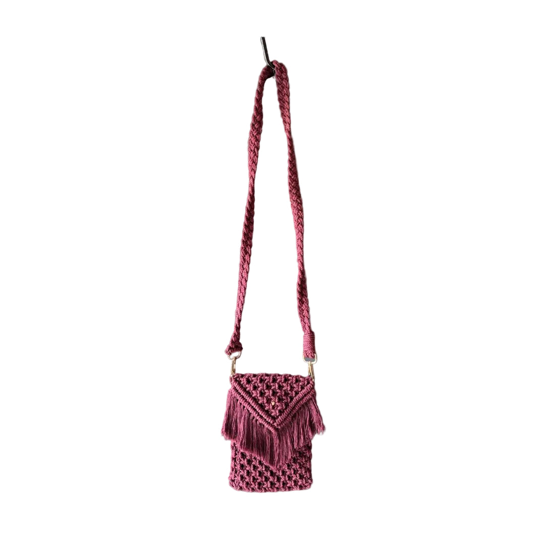 Maroon macrame small bag with a long handle placed against a grey background