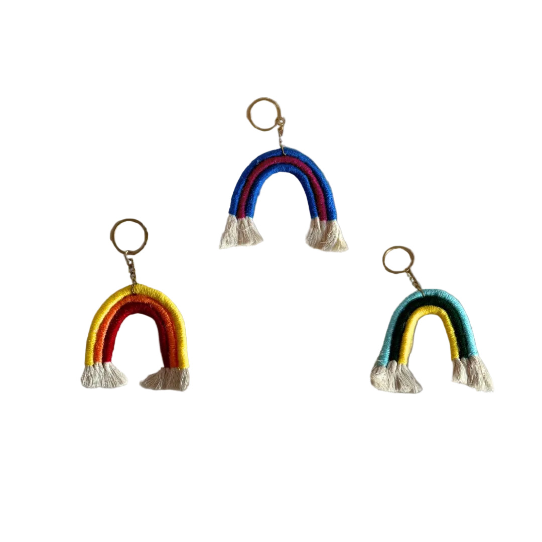 Trio coloured, rainbow shaped key ring done in macrame placed against a grey background
