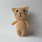 Crochet plush cat placed against a white background 