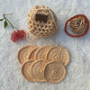 A set of peach hand crocheted face scrubbies with a matching pouch, displayed on a soft surface with light decor in the background 
