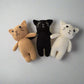 Crochet plush cats in brown, black and white placed against a white background 