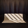 Chevron grey and purple sofa throw placed on a black sofa with black curtains in the background 