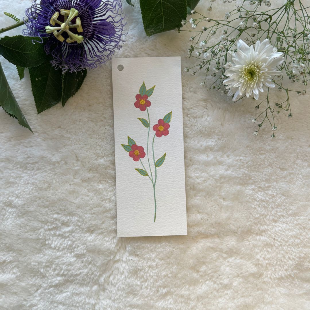 A painted bookmark with flowers in the background placed on textured background 