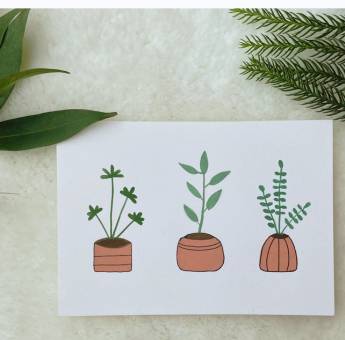 Painting of three brown plant pots on a card placed on a white background with fresh leaves 