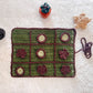 Handmade crochet game board of tic tac toe with flowers on a textured surface