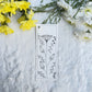 Floral sketch in black and white on a bookmark placed on fur fabric with fresh flowers in the background 
