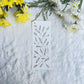 Abstract leaves sketch in black and white on a bookmark placed on fur fabric with fresh flowers in the background 