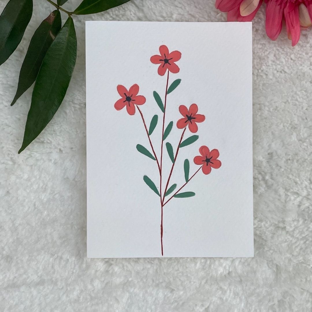 Hand painted greetings cards with peach flowers on a white card placed on a fur background