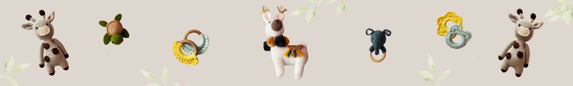 Collection of crochet plush toy and teethers including a giraffe, monkey, and bear on a light gray background.
